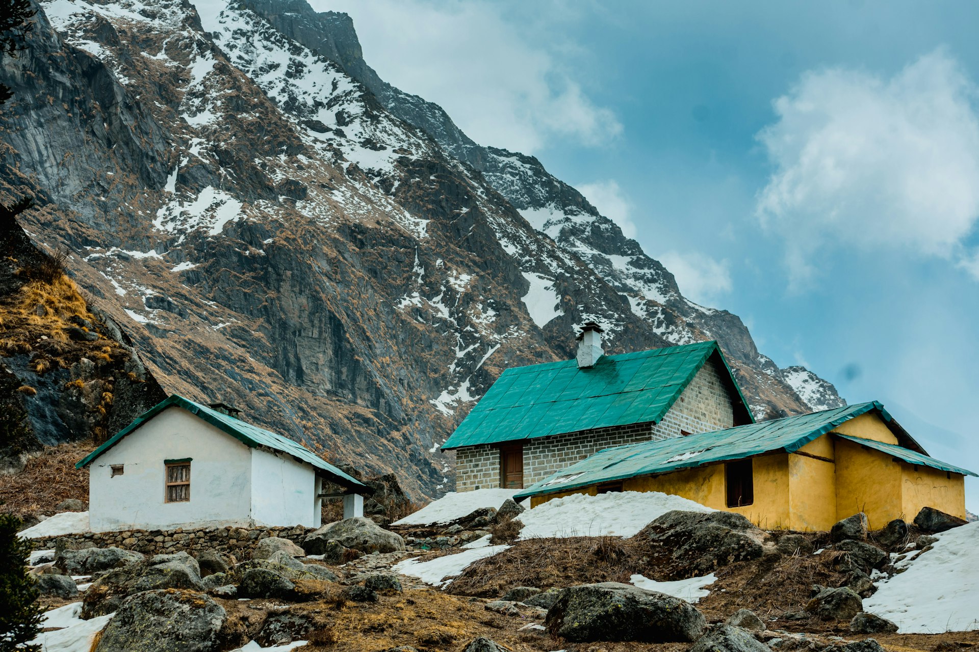 green house near snow covered mountain during daytime
